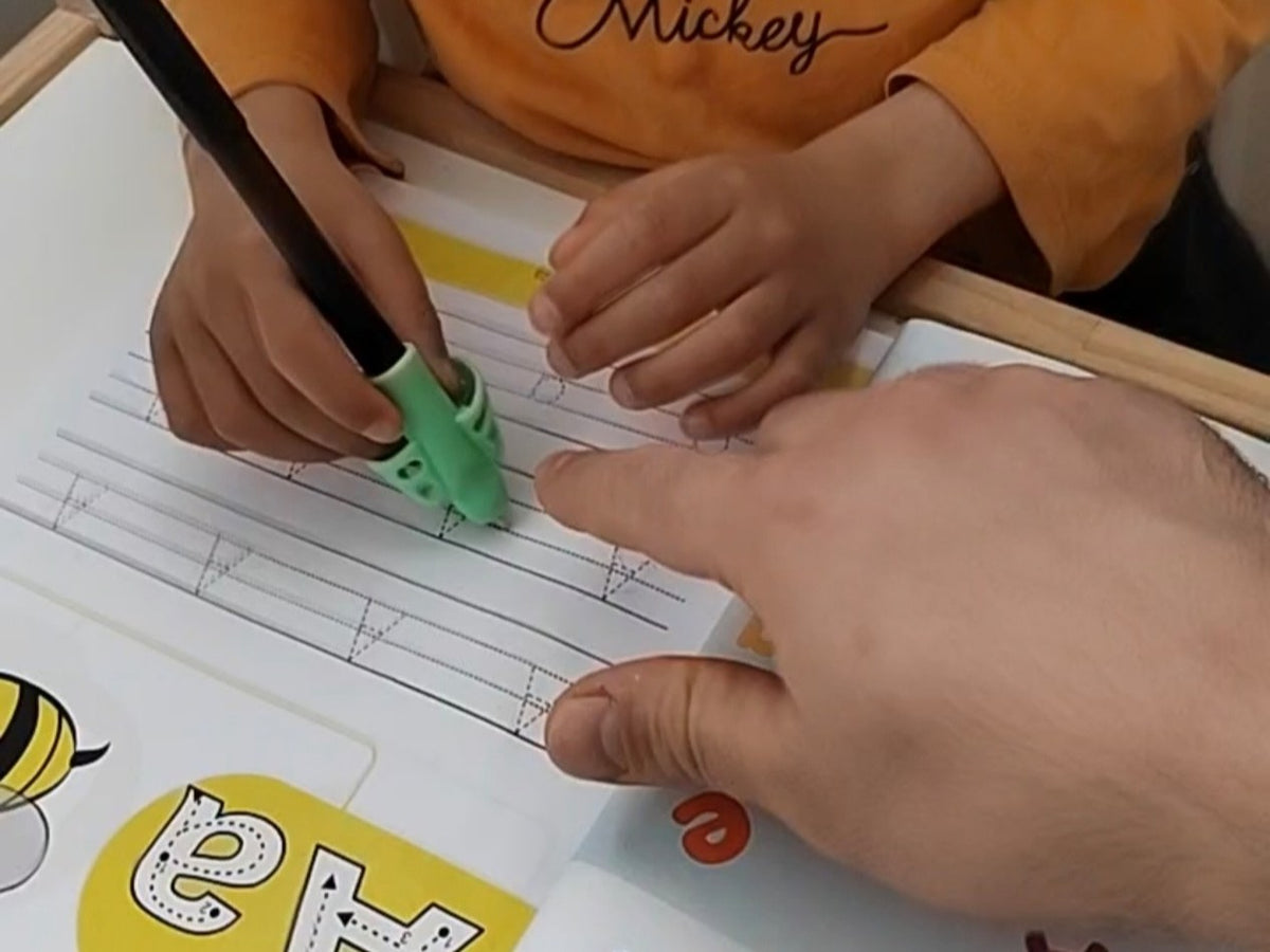 Enfant qui écrit avec un guide-doigts, projet Autiract