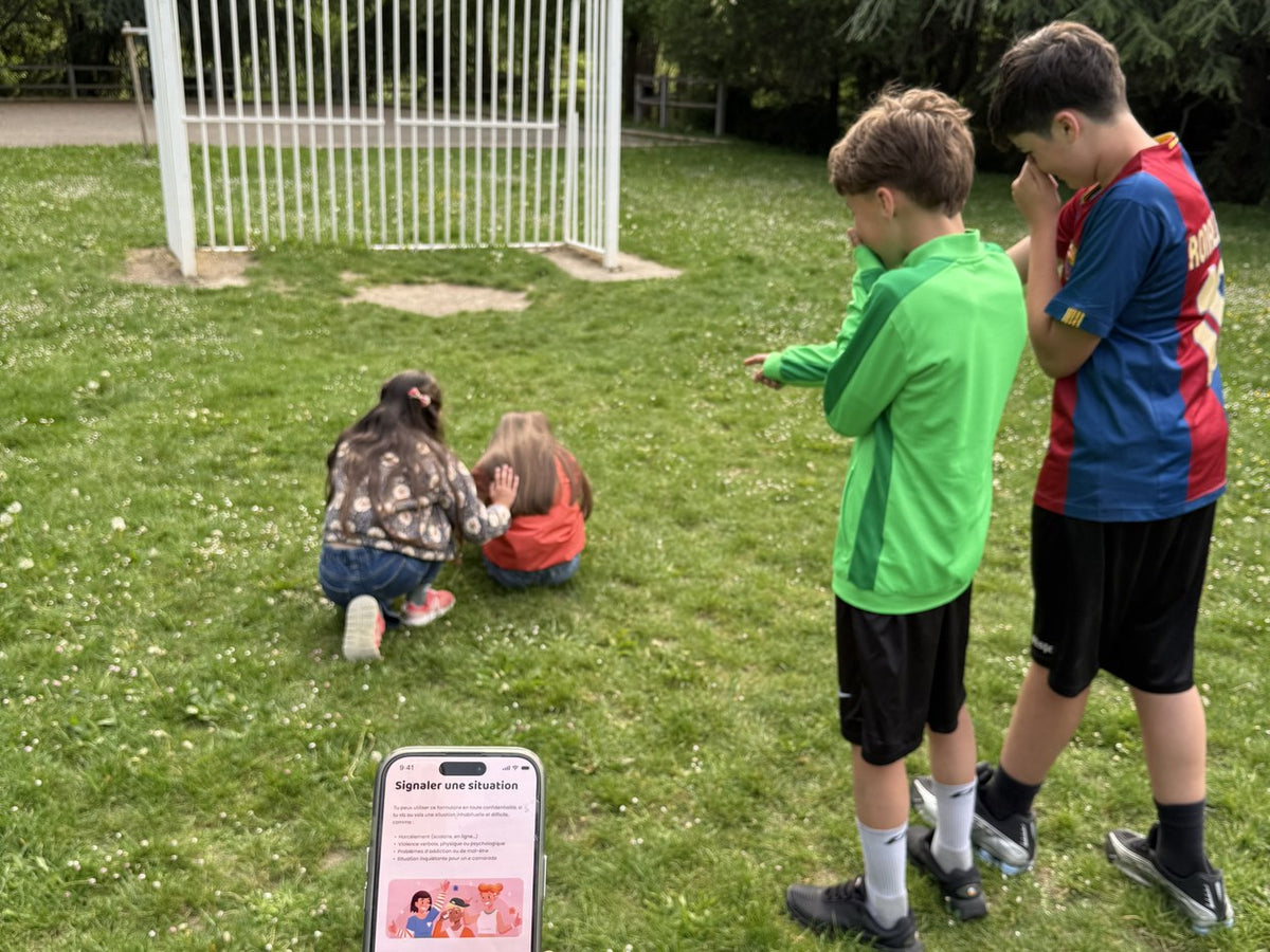 Enfants dans une cour d'école utilisant l'application Prevent' School